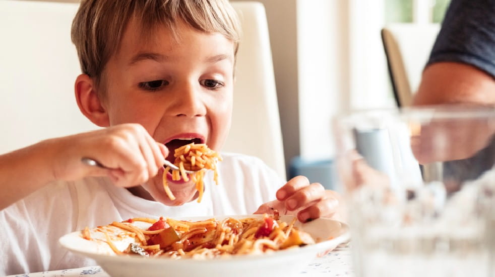 Boy eating pasta